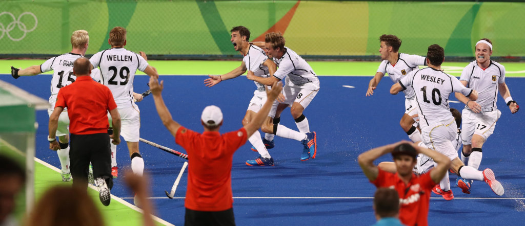 RIO DE JANEIRO, BRAZIL - AUGUST 14: Florian Fuchs of Germany is mobbed by team mates after scoring the match winning last second goal during the Men's hockey quarter final match between the Germany and New Zealand on Day 9 of the Rio 2016 Olympic Games at the Olympic Hockey Centre on August 14, 2016 in Rio de Janeiro, Brazil. (Photo by David Rogers/Getty Images)